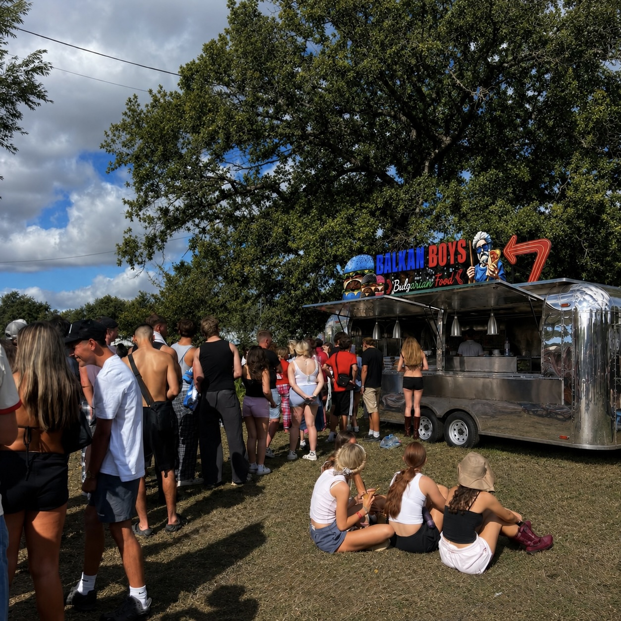 Festivalgoers gathering at the silver ballkanboyz trailer on a sunny day